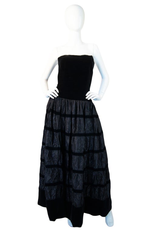 This is an over the top, unbelievable silk taffeta and velvet gown from Chanel. If I am reading the hand written tag correctly it is from the Autumn Winter collection 1986. The dress is both simple and elaborate. Simple in that it is basic black and