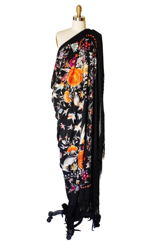 Gorgeous embroidered silk Chinese export shawl that is from the twenties. It is a spectacular explosion of flowers, cranes and butterflies done in a satin stitch. The colors are as vibrant as the day it was done and are perfectly set off against the