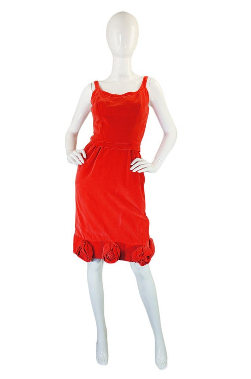 What a stunner! This is that holy grail type dress for my fifties and sixties vixens! Made by Emma Domb and out of a coral hued cotton velvet, it is cut classic body hugging, curve creating wiggle style. A curved neckline sits atop a fitted bodice