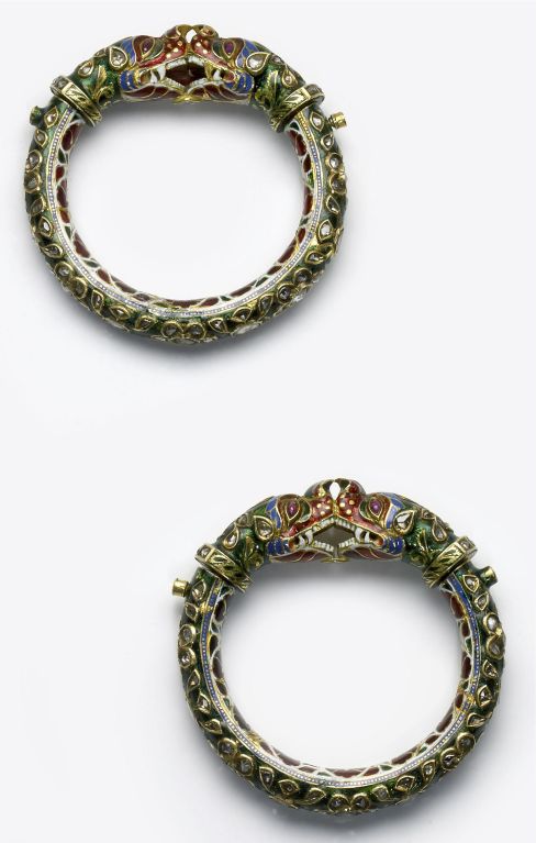 A pair of gold and enamelled makara head bangles, each bangle set with table-cut diamonds around the outside of the shank in gold collets set in the kundan style in green enamel (sabz zamin). The makara heads have diamonds set in the ears and around