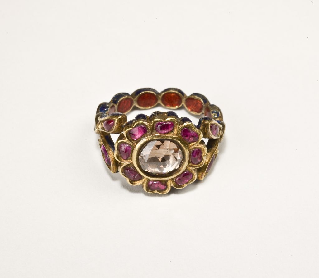 A gorgeous diamond ring set within a flower of rubies. The shank set with diamonds and the reverse beautifully enamelled.