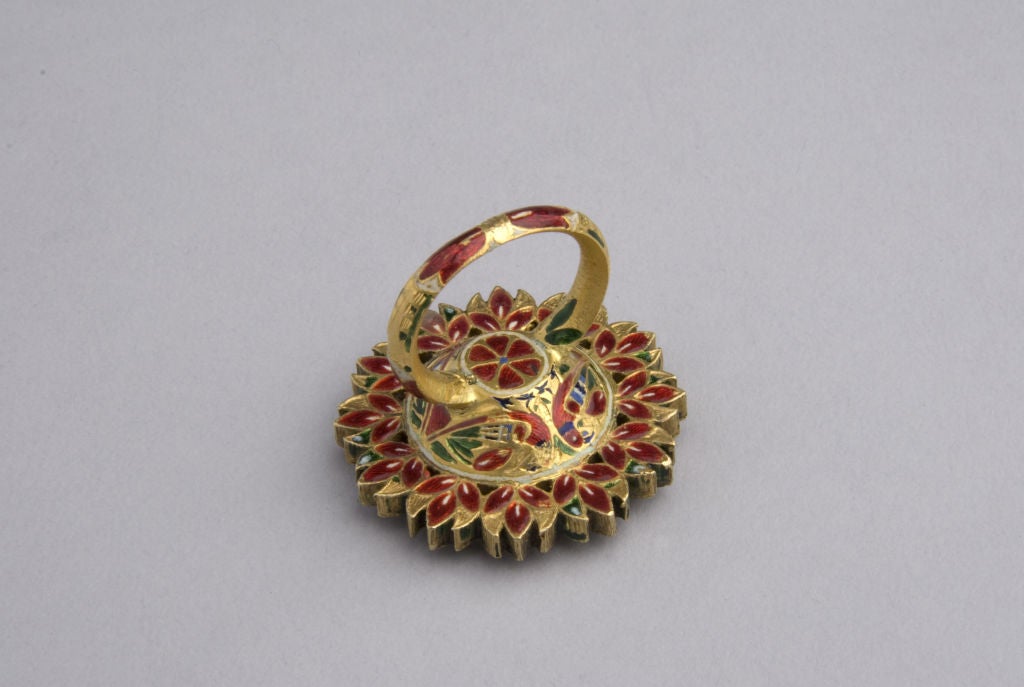 A mirror ring inset with a central foiled crystal and surrounded with rubies and diamonds and finely enamelled on the reverse.