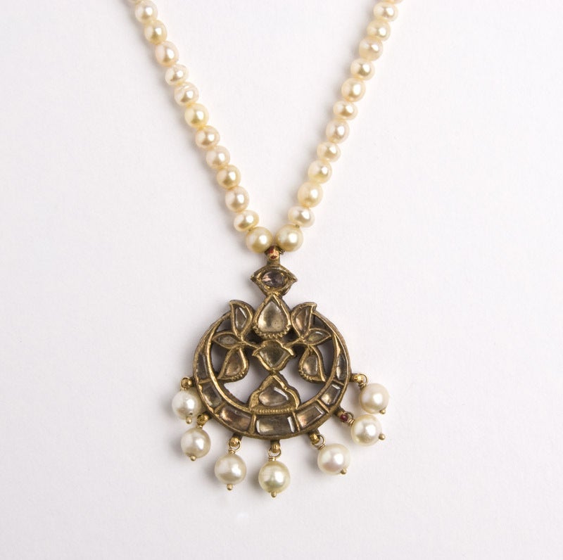 A natural basra pearl necklace with Mughal tikka pendant set with flat cut diamonds and enamelled on the reverse