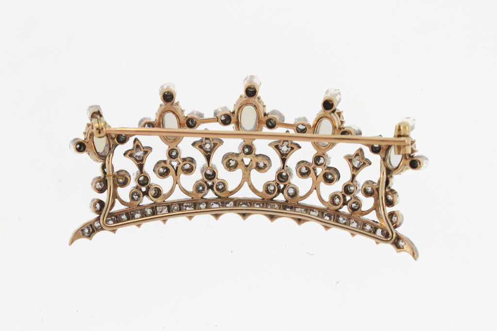 Own your own version of royalty.  This sweet and delicate brooch is designed as a tiara set with mine-cut diamonds and billowy blue cabochon moonstones.