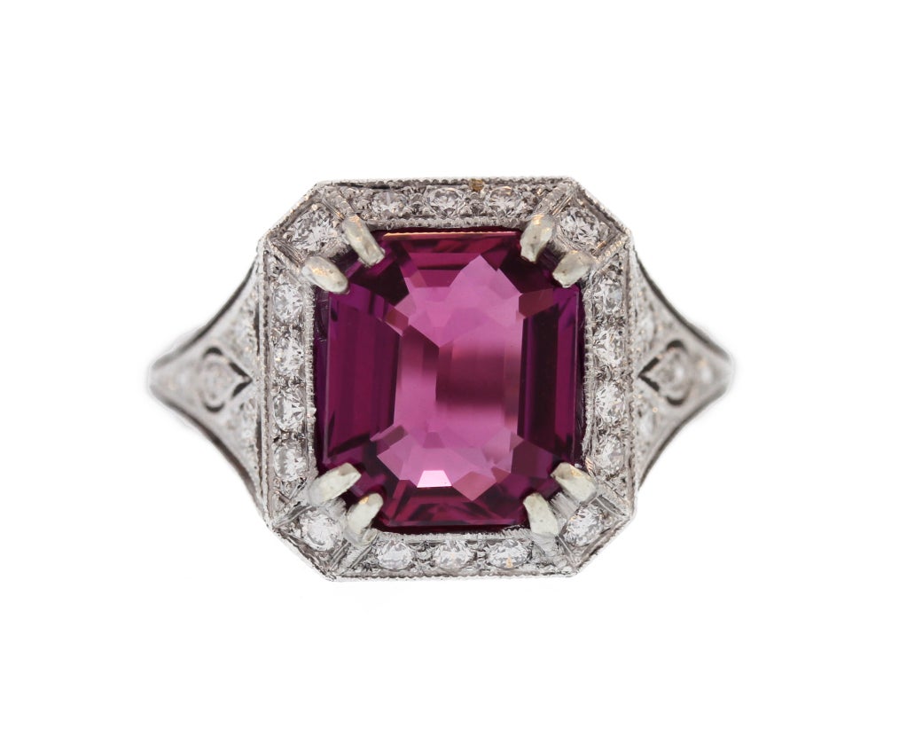 This stunning ring features an emerald-cut near flawless unheated and untreated gem pink sapphire weighing exactly 4.03 carats.  Within an ornate open work platinum setting set with round diamonds, this ring is of top quality and is feminine and