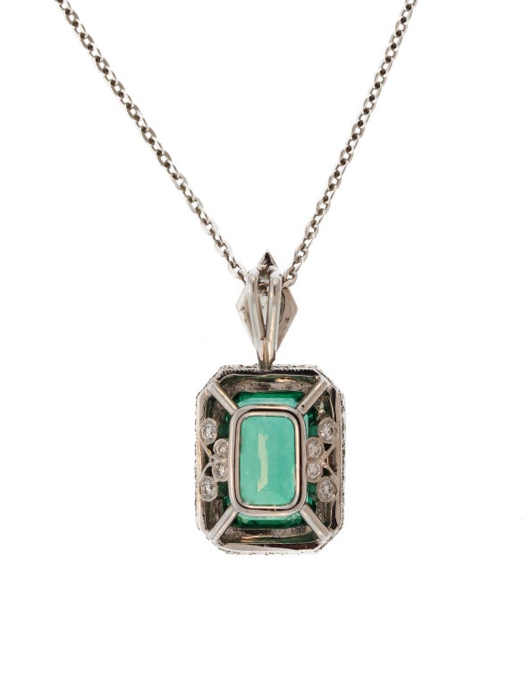 This beautiful emerald and diamond pendant features an emerald-cut emerald weighing 2.94 carats framed by round diamonds and surmounted by a kite-shaped diamond made by Jewels by Star.  A classic design which can be worn with matching earrings