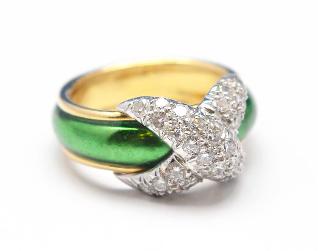 18 karat yellow gold, diamond and enamel band ring by Schlumberger for Tiffany & Co., designed as a slightly graduated band applied with translucent green enamel, the front applied with a crossover platinum plaque pave-set with round diamonds