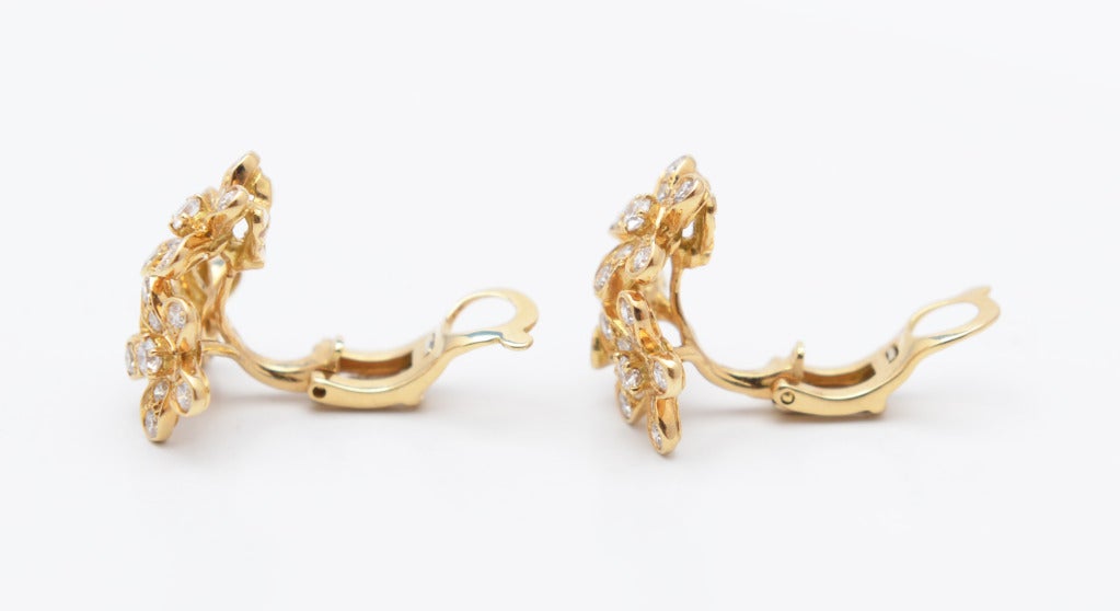 Pair of 18 karat yellow gold and diamond 'Socrate' earclips by Van Cleef & Arpels, designed as clusters of flowers pave-set with 66 round diamonds weighing approximately 1.50 carats, gross weight 7.4 grams, measuring 5/8 by 5/8 by 3/8 inch, signed