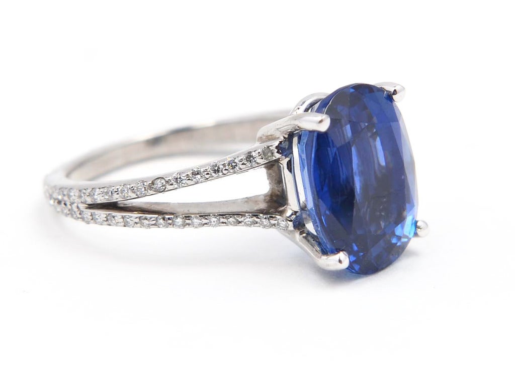 Platinum, sapphire and diamond ring, set in the center with a bright vivid blue oval sapphire weighing 6.15 carats, flanked by small round diamonds weighing approximately 0.75 carat, size 5 1/2, gross weight 5.6 grams, stamped PT950, measuring 3/8