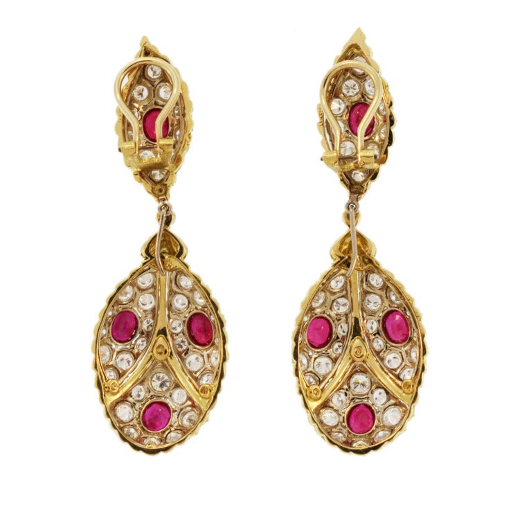 These beautiful day and night earclips are of bombe and textured gold design set with oval rubies weighing approximately 4.00 carats, accented by round diamonds weighing approximately 6.00 carats, measuring 2 1/2 by 3/4 inch, signed M. Buccellati,