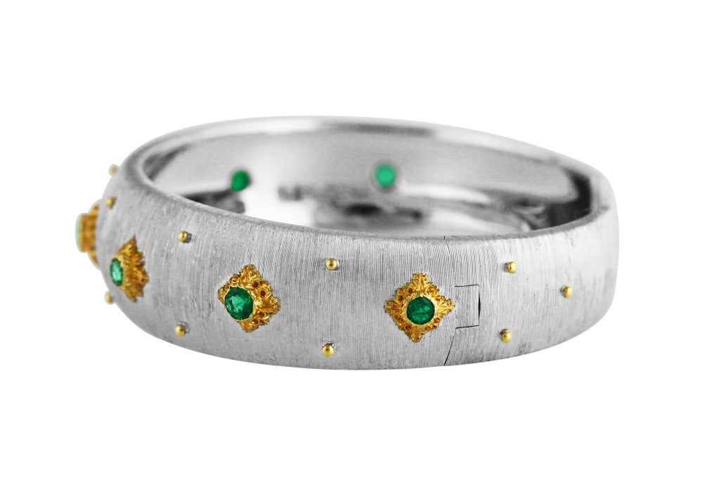 18 karat white and yellow gold and emerald 'Macri' cuff bracelet by Buccellati, designed as a slightly tapered band of textured gold set with 7 round emeralds weighing approximately 1.05 carats, gross weight 31.5 grams, length 6 1/2 inches, width