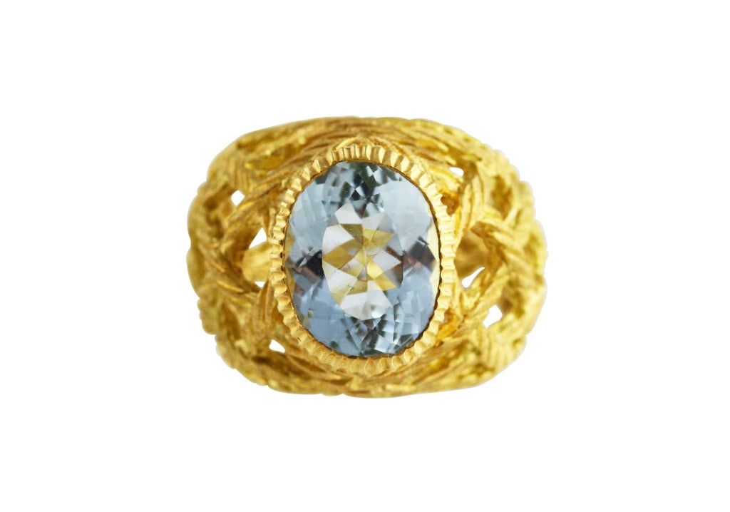 18 karat yellow gold and aquamarine 'Crepe de Chine' ring by Buccellati, of tapered design composed of interlocking rope twists bands, set in the center with an oval aquamarine weighing approximately 4.65 carats, gross weight 13.0 grams, size 5 1/2,
