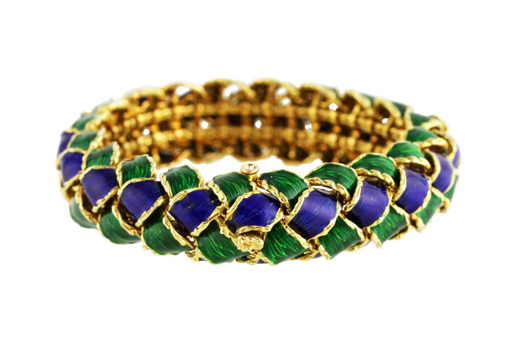 Tiffany Schlumberger 18 karat yellow gold and enamel bracelet. designed as interlocking curved links applied with blue and green enamel, gross weight 79.1 grams, length 6 1/2 inches, width of band 5/8 inch,  Made in France, with French assay mark.