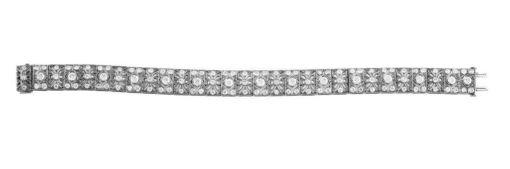 Art Deco platinum and diamond bracelet of simple elegance by J.E. Caldwell, designed as openwork ornate plaques set wtih 117 old European-cut diamonds weighing approximately 5.50 carats, gross weight 31.7 grams, length 6 3/4 inches, width 3/8 inch,