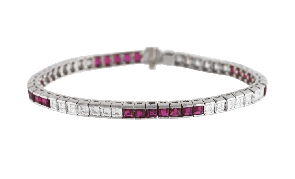 This classic platinum, diamond and ruby straightline bracelet, set with 28 square-cut rubies weighing 6.46 carats, and 28 square-cut diamonds weighing 4.48 carats, gross weight 25.7 grams, length 7 inches, width 3/16 inch, stamped 6.46 and 4.48 for
