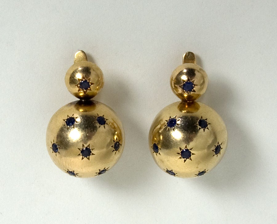 Unusual Retro fourteen karat gold earrings with sapphires. Stones are set in star-like bezels typical of the 1940's. Measures one inch long and 5/8 