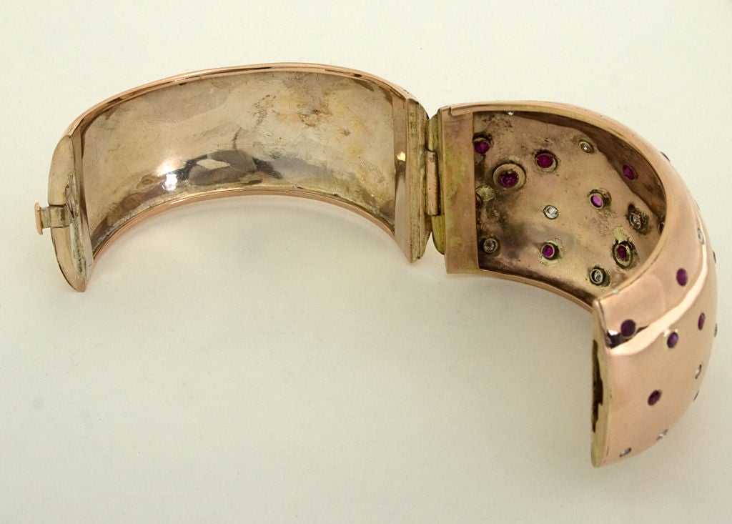If bigger is better, this huge Retro Cuff Bracelet is the best. It measures 2 inches wide.  It is made of fourteen karat rose gold scattered with rubies and diamonds.
The inner diameter is 2 1/2 inches. Tongue and groove clasp is very tight.