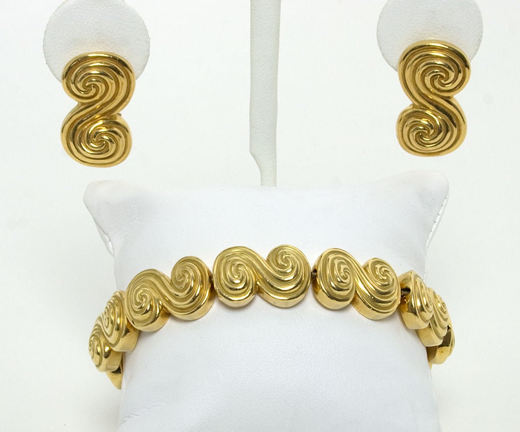 Eighteen karat gold scrolled links bracelet and earrings by Tiffany. Each link is deeply carved; the high points are smooth while the indented area are matte. Bracelet measures 7 1/2