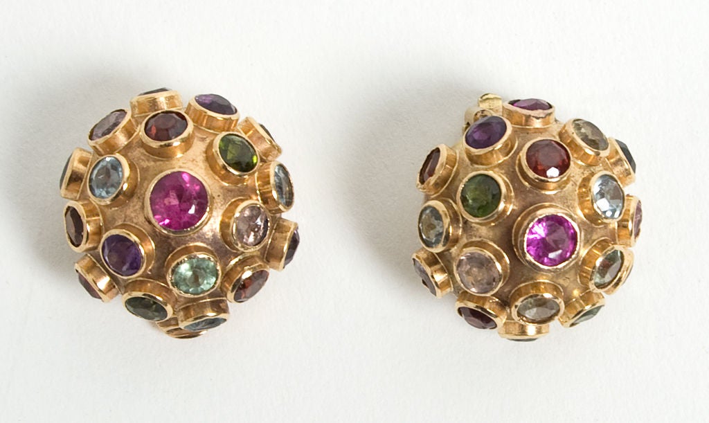 Fourteen karat domed earrings set with a wonderfully colorful array of semi precious stones. The center stone, a pink tourmaline, is larger than the others. The stones include garnet; peridot; citrine; topaz and amethyst. Clip backs, one of which