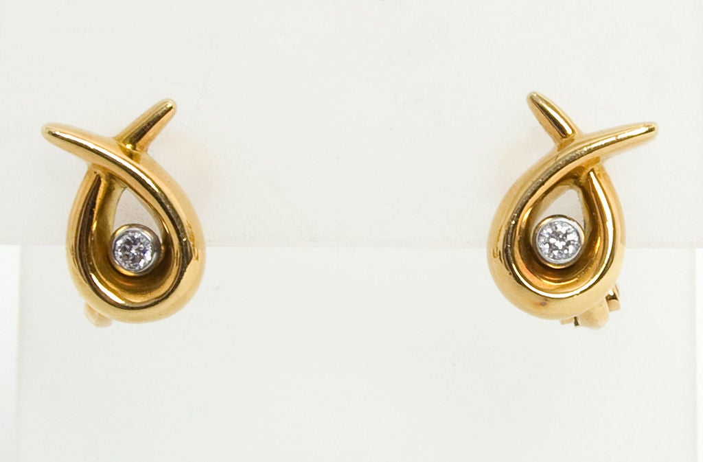 Lighthearted eighteen karat gold and diamond earrings by the famed London firm of Asprey and Garrard. Diamonds are each about 1/4 carat. Earrings are 5/8