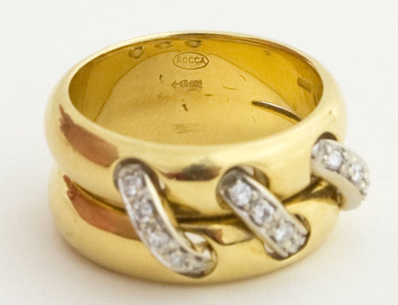 Unusual double gold band with three rows of diamonds that look as though they are laced through the gold. The ring is 3/8