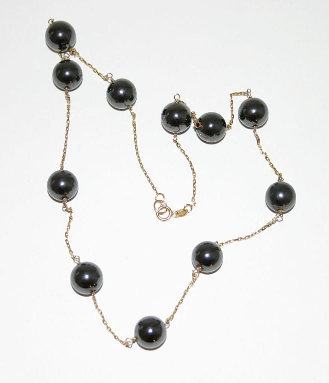 Fourteen karat gold necklace interspersed with 11 hematite beads. Chain measures 19 1/2