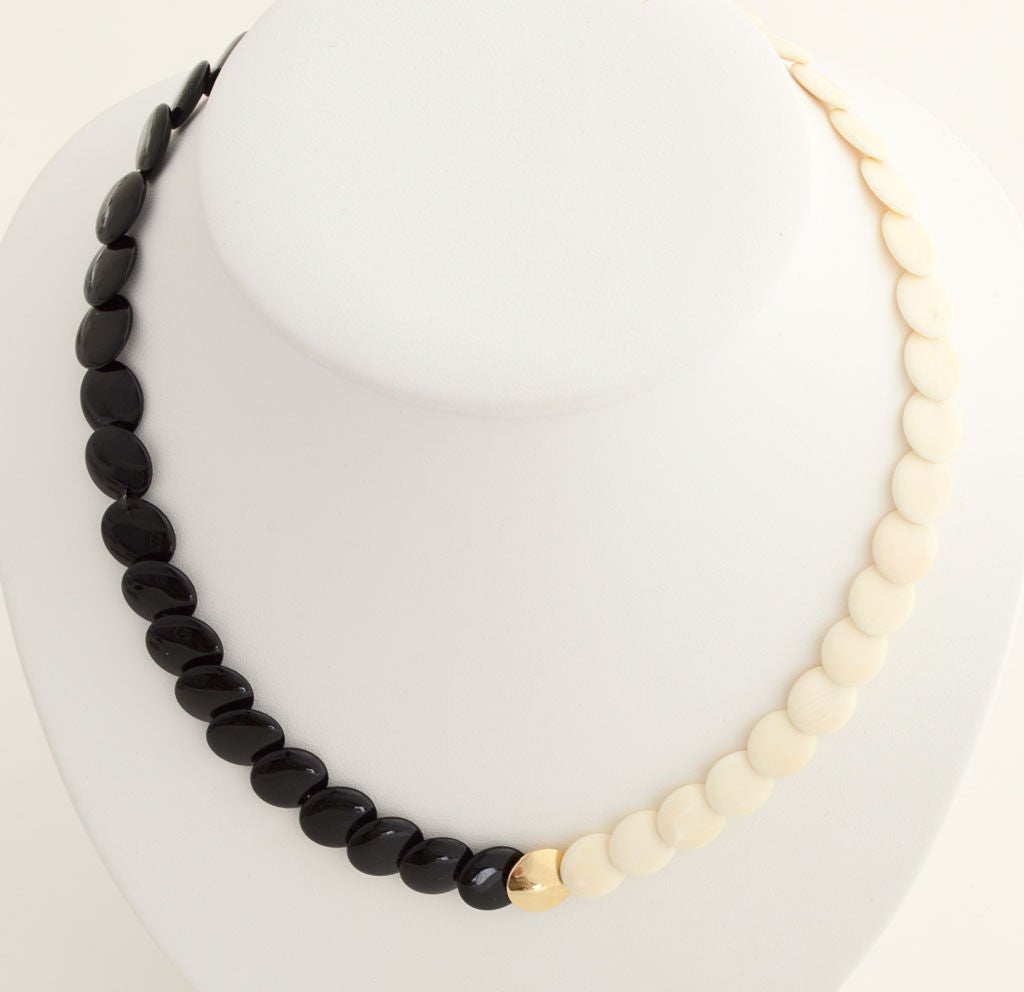 Lovely YinYang necklace of black onyx and white coral centered with fourteen karat gold. Stones are 1/2 inch in diameter. Necklace measures 16 3/4