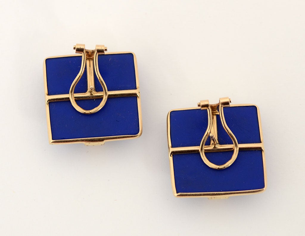 Stylish square earrings of fourteen karat gold links overlapping opaque blue glass. They measure 1