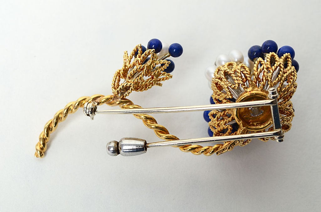 This Cartier floral brooch is cheerful and colorful. Diamonds add a touch of sparkle to the pearls and lapis lazuli. It is substantial enough to make a statement yet light enough to wear on a blouse or sweater.
