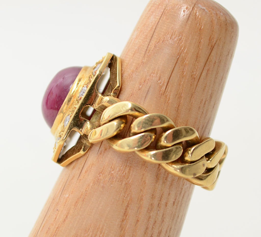 Unusual cabochon ruby ring set in an octagon of gold and surrounded by 10 diamonds with a curb chain band. The flexibility of the links makes the ring supremely comfortable to wear. It is size 7. The gold plaque measures 3/4