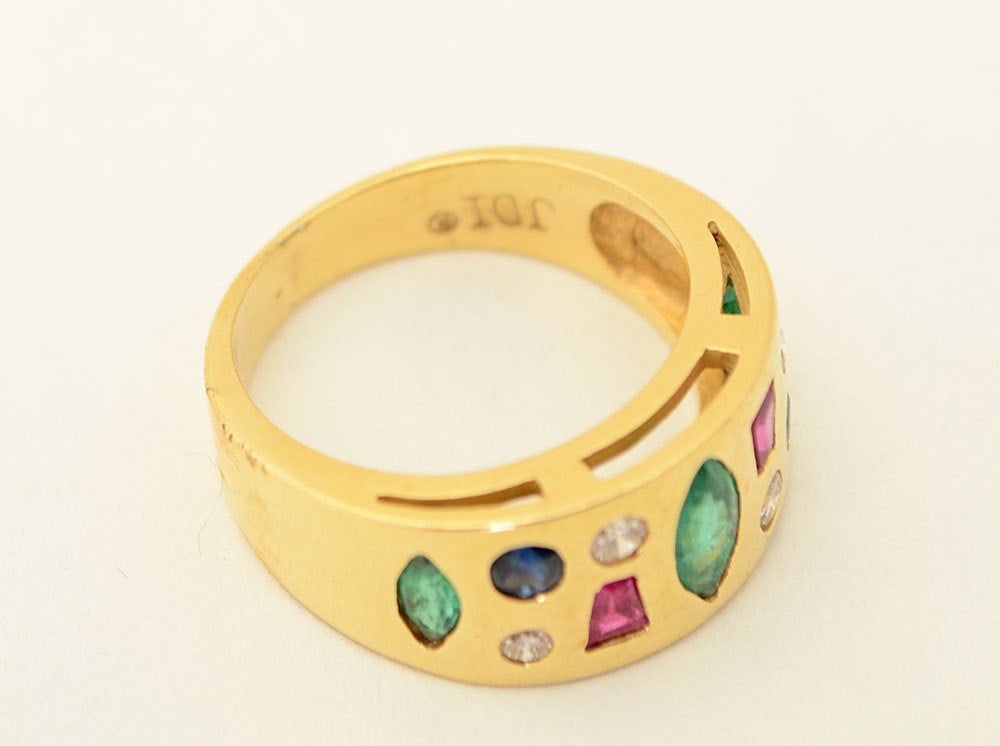 Bunter 18-karätiger Goldring mit einer Vielzahl unterschiedlich geformter Steine aus Smaragd:: Saphir:: Diamant und Rubin. Signiert JD. Größe 6:: kann aber leicht vergrößert oder verkleinert werden.