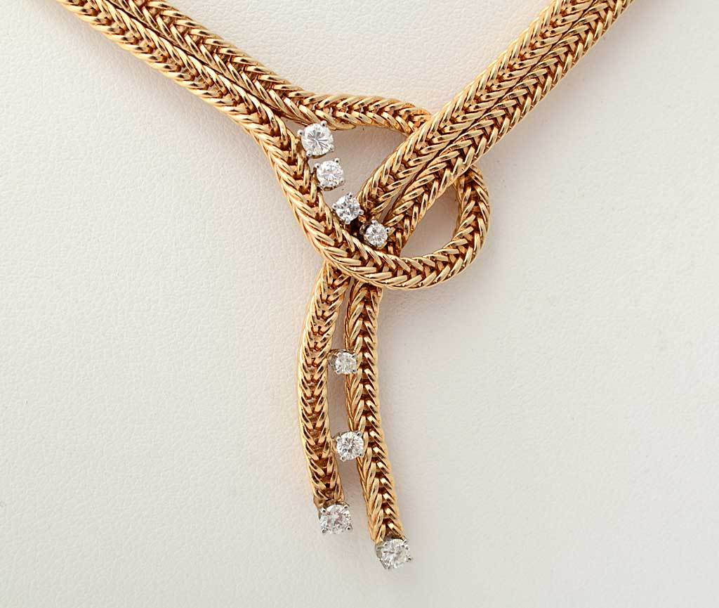 An unusual lasso Retro necklace in fourteen karat gold with 8 diamonds. The lasso consists of a double herringbone chain that is 1/4