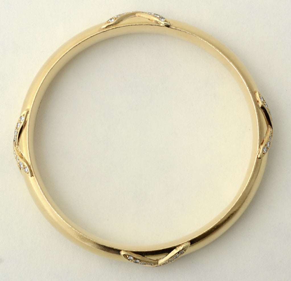 Wonderful, substantial weight gold bangle bracelet by Van Cleef and Arpels with four X's of diamonds. Inside diameter is 2 1/2