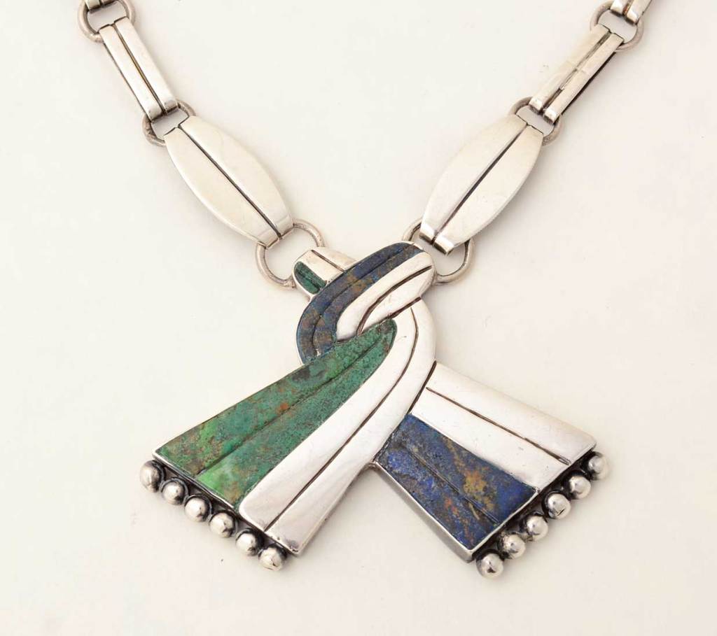 Rare necklace by silver master, William Spratling. The use of two colors of malachite makes this example even more unusual. It gives the effect of fabric being folded over and under. The chain measures 20