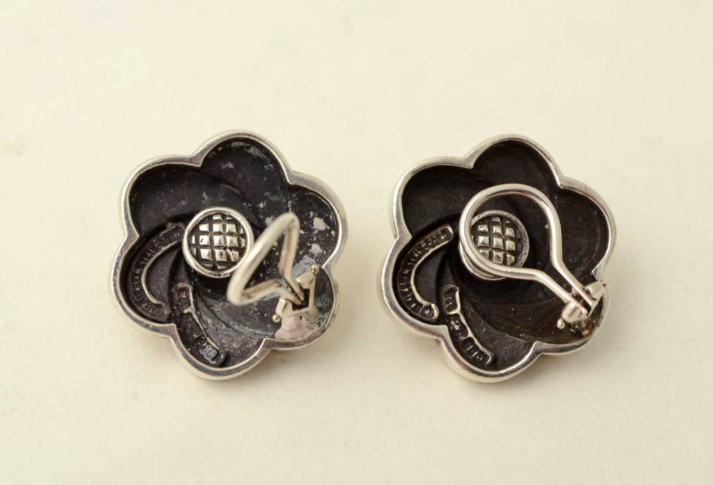 Stylized flower earrings by Barry Kieselstein Cord. They have a nice swirling design resembling a pinwheel. Backs are clips that be converted to posts. Substantial in depth as his jewelry always is.