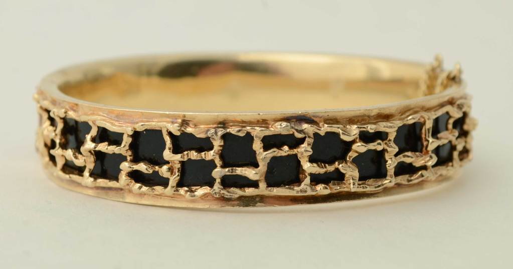 Artisan made gold and enamel bangle with the texturing usually seen in the 1960's. It has a clasp for opening allowing it to be worn on many size wrists. When closed, the inside diameter is 2 3/8