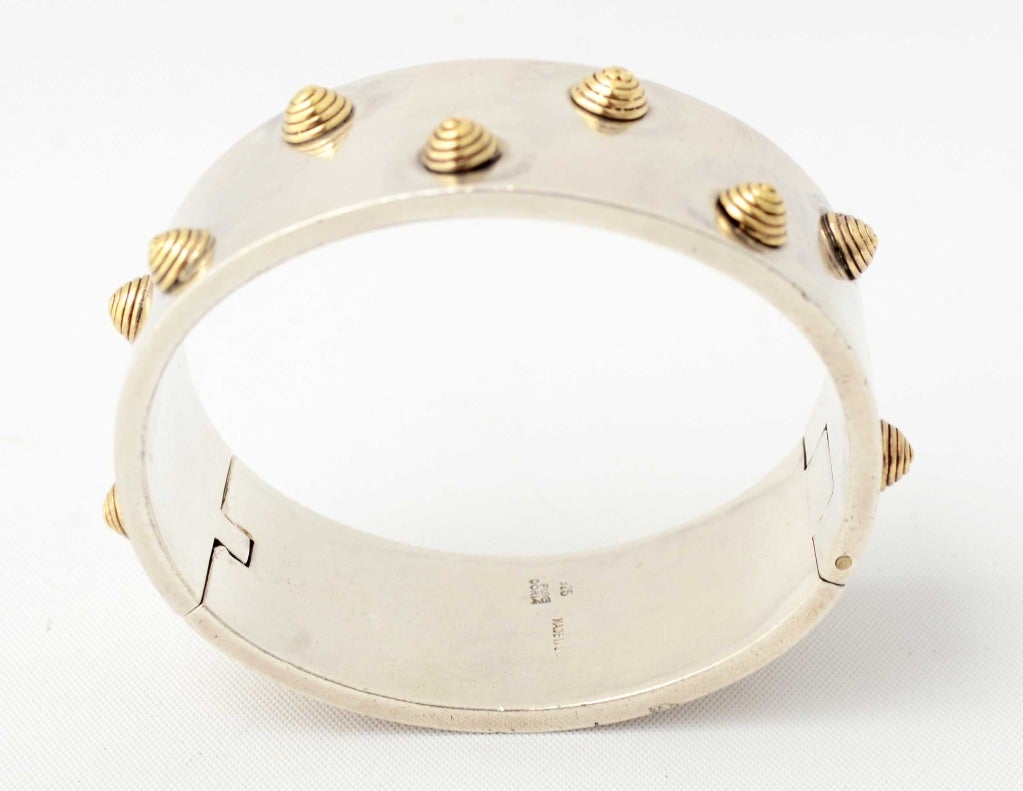 Heavy silver bracelet on which are mounted three dimensional gold coils. The inner diameter is 2 3/16