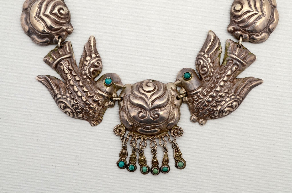 Showstopper sterling silver necklace by Matilde Poulat (who worked under the name of Matl) in her classic repousse style. The necklace combines her favorite motifs of birds and flowers with strategic addition of turquoise stones. It measures 18 3/4