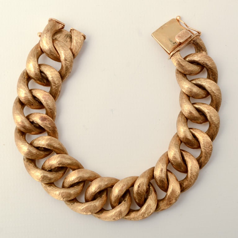 Bold  (101 grams) curb chain link bracelet in 14 karat gold. The links have a finish of very fine striations. It is 7 3/4