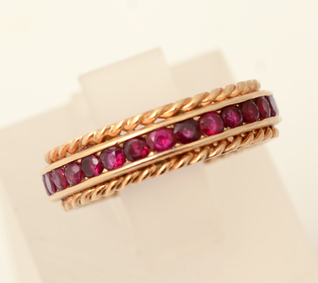 Ruby band by Tiffany in which the stones are flanked by a row of twisted gold on  either side. Band is size 6 1/4. It is 3/8