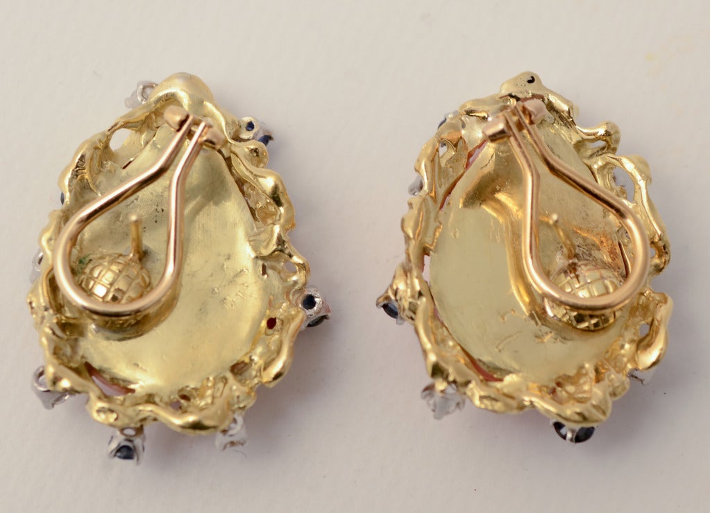 Large pear shaped coral earrings are surrounded by sapphires and diamonds. 
Measure 1 1/4