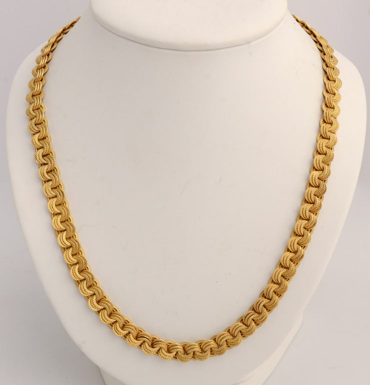 Groups of three textured circles overlap in this 18 karat gold necklace that is 36
