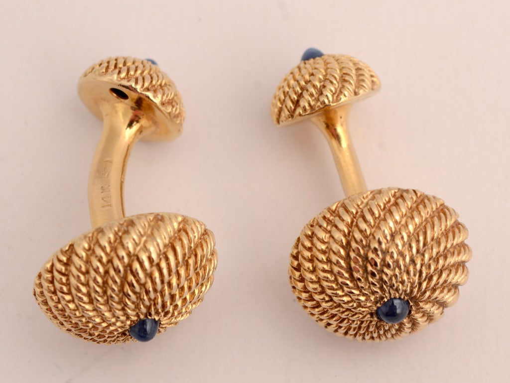 Two sided 14 karat gold cufflinks of textured domes centered with sapphire. Measure 1 1/4