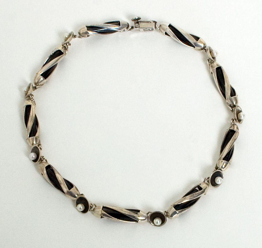 Unusual necklace by silver master, Antonio Pineda, incorporating both pearls and  obsidian. Bars of obsidian are encased in links of swirled silver. Measures 17 1/4