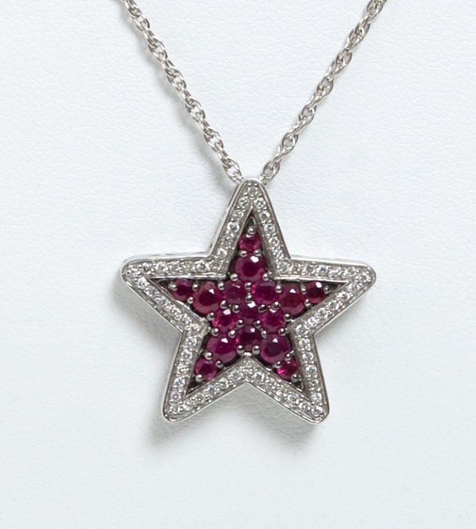 Lovely five arm star pendant with rubies framed by diamonds. Star is 7/8