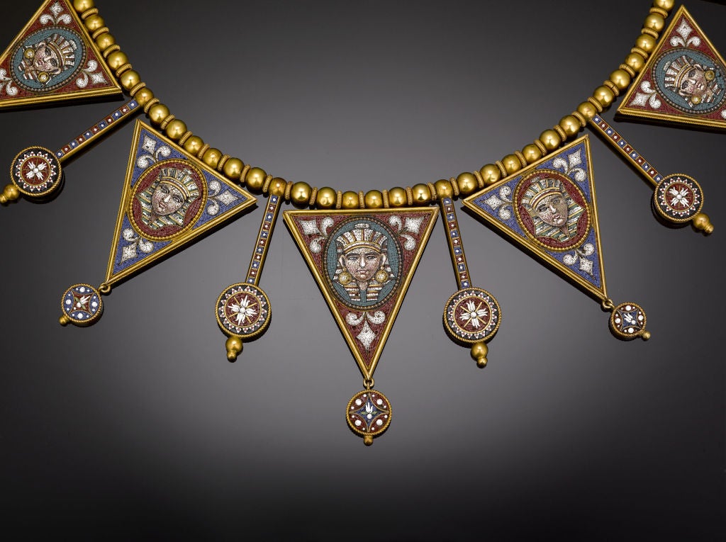 This stunning Victorian Egyptian Revival necklace, comprised of 21 individual micromosaic pendants, is a wonder of meticulous craftsmanship and intricate beauty. Crafted of sumptuous yellow gold, the necklace exhibits a magnificent inlaid Egyptian