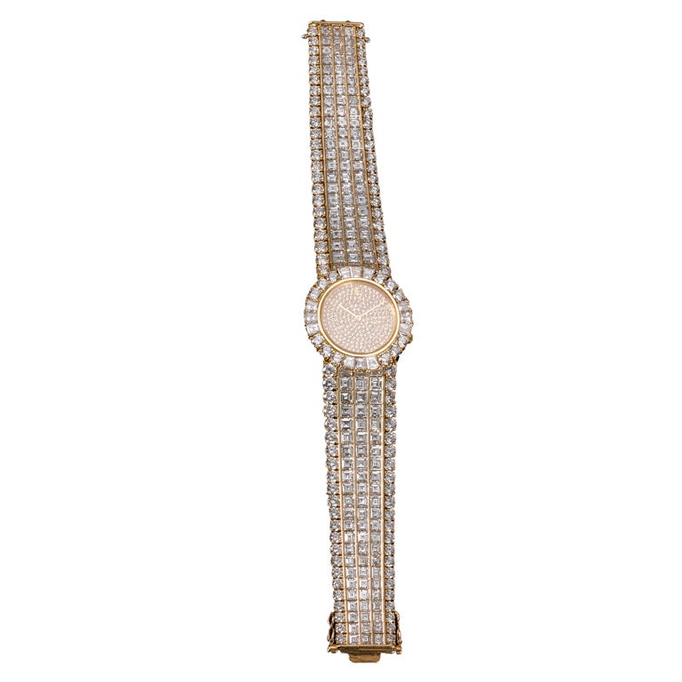 This outstanding watch by Corum, the renowned Swiss watch manufactory, is generously adorned with approximately 65.00 carats of sparkling diamonds. Constructed of 18-carat yellow gold, this magnificent quartz timepiece features rows of square and