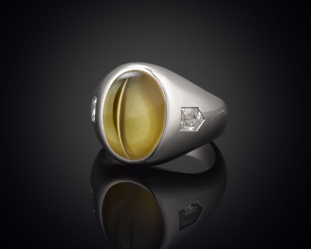 A spectacular cat’s-eye chrysoberyl makes an impression in this elegant gentleman’s ring. Displaying an exceptional example of the phenomenon known as “chatoyancy,” wherein light reflects off of small inclusions in the stone to marvelous effect,