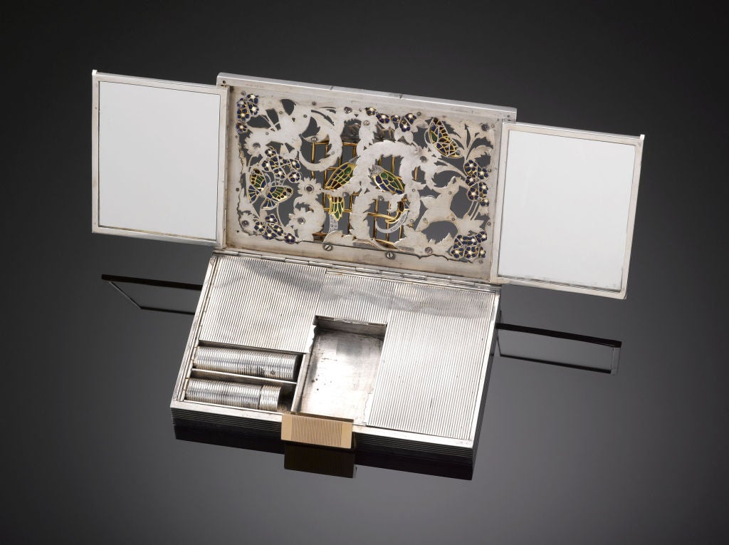 This important and rare French  miniaudiere, or vanity case, created by the famed jewelry house Boucheron, is a work of outstanding artistry, luxury and poignant symbolism. On the exterior, the case's lid boasts a stunning design of a pair of