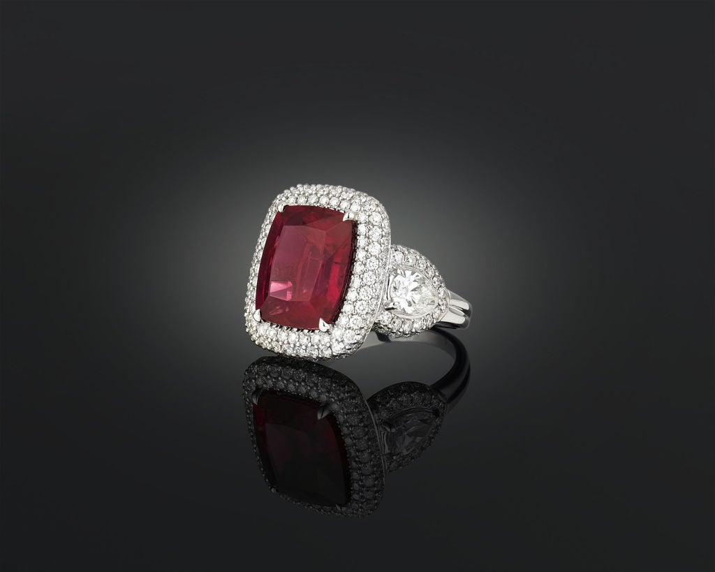A stunning, deep crimson rubellite totaling 8.03 carats is nestled amongst 2.92 carats of shimmering white diamonds in this 18K white gold ring. This red form of tourmaline derives its name from the Latin 
